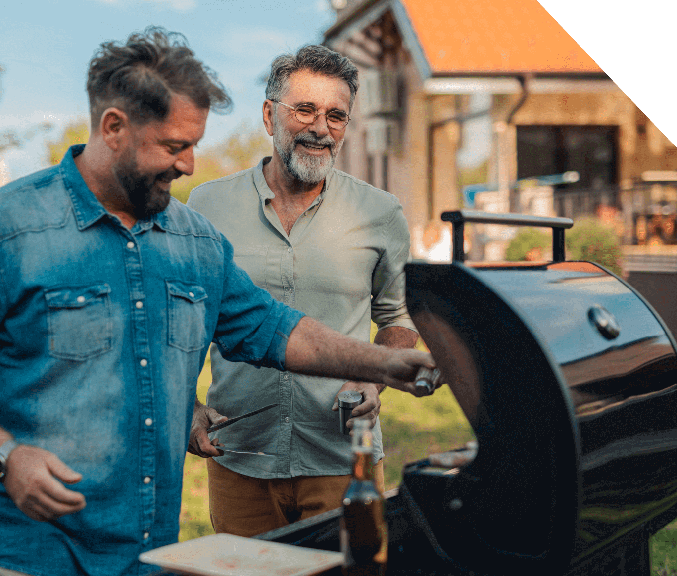 Two men grilling outside on a barbecue.