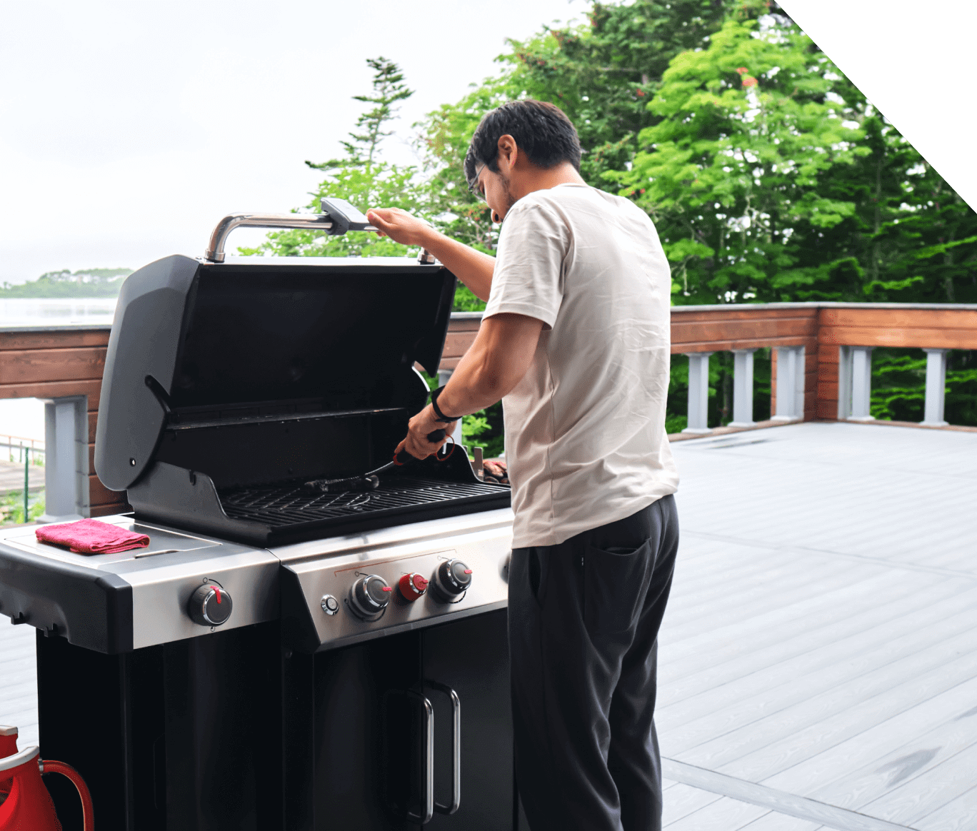 Man grilling on outdoor deck barbecue.
